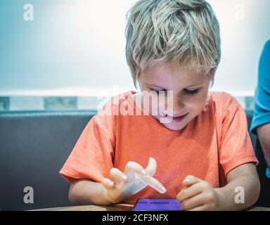 L'intérêt du garçon sur l'écran du smartphone. Téléphone comme l'éducation ou la dégradation du développement, absorber l'obsession de l'habitude de jeu, vivre le monde virtuel, danger Banque D'Images