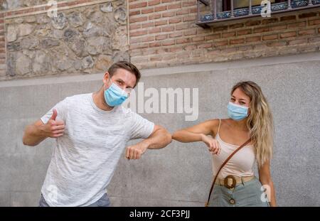 Salutation plus sûre dans la nouvelle norme. Homme et femme secouant le pied et le coude secouant en gardant la distance sociale pour éviter la propagation du coronavirus. COVID-19 Banque D'Images