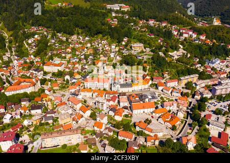 Vue aérienne générale de la petite ville d'Idrija entre vert Collines dans l'ouest de la Slovénie par beau temps Banque D'Images