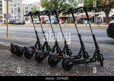 Six e-trottinettes de la société Bird dans une rangée sur Le trottoir de Berlin Banque D'Images