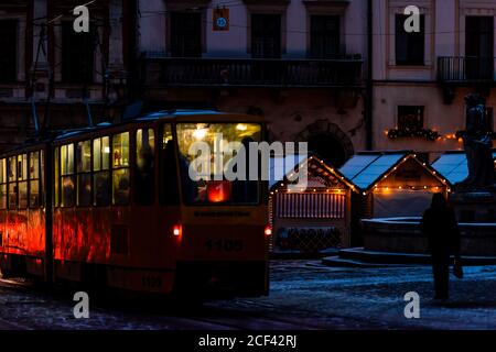 Lviv, Ukraine - 28 décembre 2019 : place du marché de la vieille ville de rynok à Lvov avec éclairage de Noël en hiver et lumières de tram illuminées la nuit sombre Banque D'Images