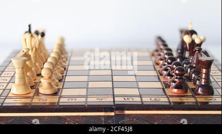 Pièces d'échecs noir et blanc disposées sur le plateau d'échecs avant début du jeu comme deux armées devant chacun autre Banque D'Images