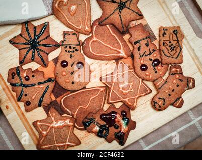 Les enfants sont décorés à la main de pain d'épice de noël en forme de biscuit figuré sur le plan de cuisine Banque D'Images