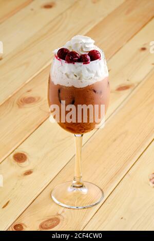 Café raf froid avec cerise en verre transparent sur bois arrière-plan Banque D'Images