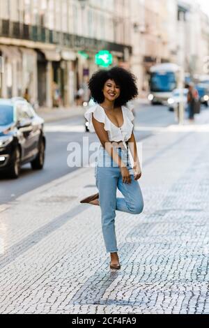 Bonne femme ethnique dans une tenue tendance et regardant l'appareil photo le jour de l'été Banque D'Images