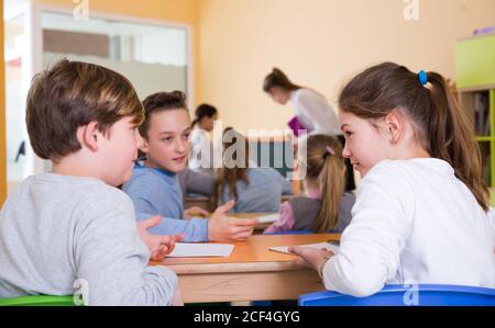 Portrait des enfants discuter quelque chose pendant la leçon à l'école Banque D'Images