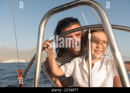 Père heureux avec des enfants flottant sur un bateau cher sur la mer et le ciel bleu par temps ensoleillé Banque D'Images