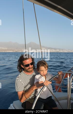 Père heureux avec des enfants flottant sur un bateau cher sur la mer et le ciel bleu par temps ensoleillé Banque D'Images