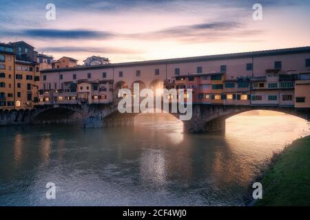 Pont de la ville avec des bâtiments au-dessus de la rivière au coucher du soleil, Florence, Italie Banque D'Images