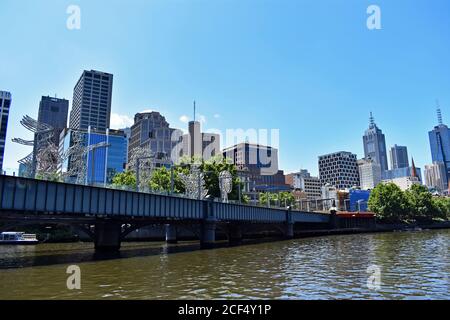 Le fleuve Yarra traverse le centre-ville de Melbourne et passe sous le. Pont ferroviaire de Sandridge. Des sculptures sont visibles sur le pont Banque D'Images