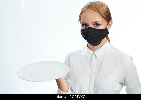 Jeune femme avec plaque vide isolée sur fond blanc de studio Banque D'Images