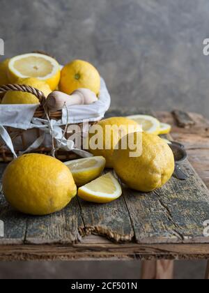 Du dessus des citrons et des agrumes alésoir placés sur un panneau en bois Banque D'Images