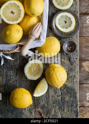 Du dessus des citrons et des agrumes alésoir placés sur un panneau en bois Banque D'Images