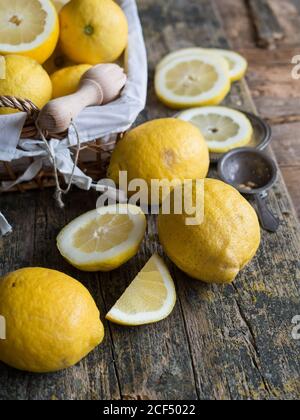 Du dessus des citrons et des agrumes alésoir placés sur un panneau en bois Banque D'Images