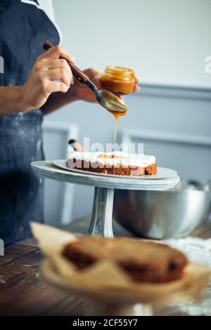 la pâtisserie cuit verse le caramel sur le gâteau Banque D'Images