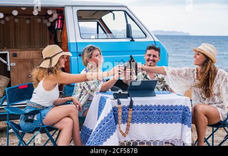 Des amis souriants et souriants qui élèvent des bouteilles de boisson et se trinquoivent vacances en voiture Banque D'Images