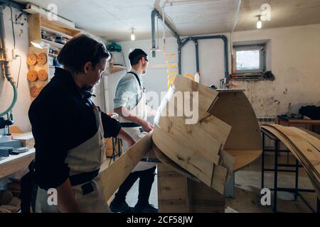 Meuble incurvé collé avec pinces. Outils de serrage à vis Carpenter pour le pressage de lattes de bois et de colle blanche Banque D'Images