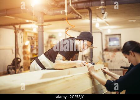Meuble incurvé collé avec pinces. Outils de serrage à vis Carpenter pour le pressage de lattes de bois et de colle blanche Banque D'Images
