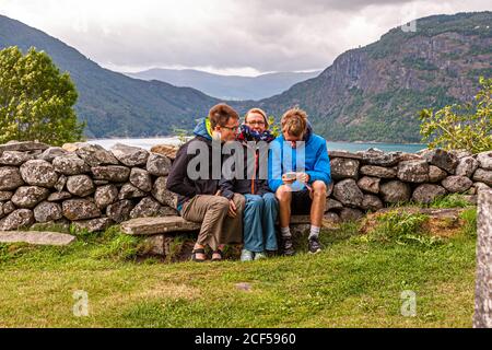 Mère avec ses fils sur un banc de pierre à Lustre, Norvège Banque D'Images