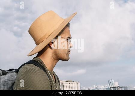 Vue latérale d'un homme avec un joli chapeau et des lunettes regardant droit devant. Destinations et concept de voyage Banque D'Images