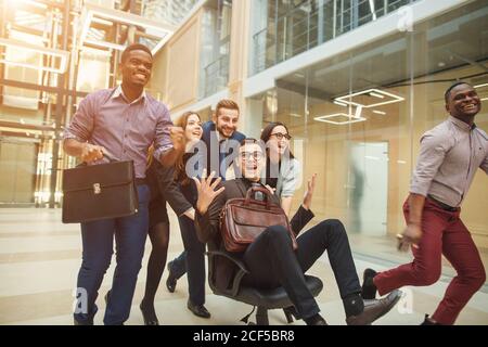 Collègues positif d'avoir du plaisir avec les chaises de bureau Banque D'Images