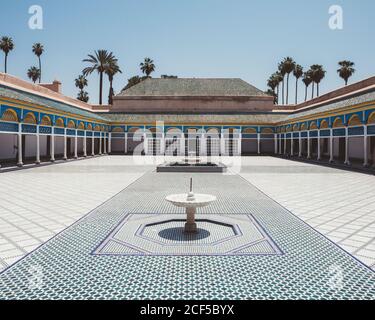 Patio avec carrelage coloré et fontaines entouré d'une galerie couverte et de piliers de style oriental, Marocco Banque D'Images