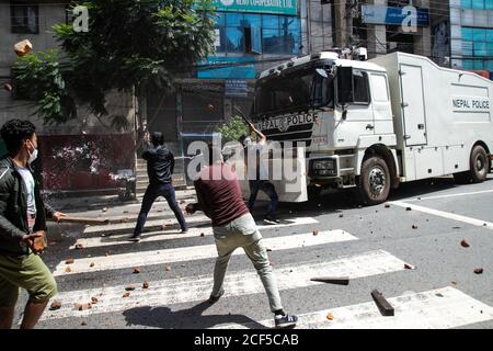 Les manifestants jettent des pierres sur un camion de police pendant les affrontements.des centaines de dévots et de policiers anti-émeutes ont été écrasés lorsque les dévots ont essayé de lancer la procession du char de Rato Machindanath. Le char fabriqué à Pulchowk de Lalitpur a été tenu pendant des mois en raison des ordres du gouvernement de ne pas célébrer les festivals annuels en raison de craintes sur la propagation du coronavirus. La statue est normalement tirée autour de la ville pendant un mois. Des policiers en tenue anti-émeute ont bloqué les manifestants lorsqu'ils ont déplacé le char, les faisant mouser avec du canon à eau et du gaz lacrymogène. Banque D'Images