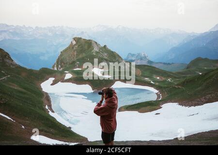 homme méconnaissable prenant des photos de paysage de montagne Banque D'Images