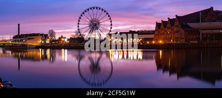 Panorama de la rivière Motlawa et de la grande roue avec reflet de l'eau dans la vieille ville de Gdansk la nuit, Pologne Banque D'Images