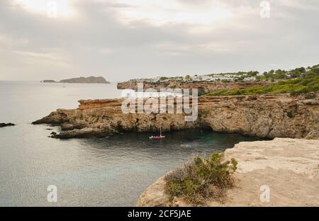 Vue pittoresque sur le rivage rocheux avec des falaises et un océan calme Eau par temps couvert à Ibiza ensoleillé Banque D'Images