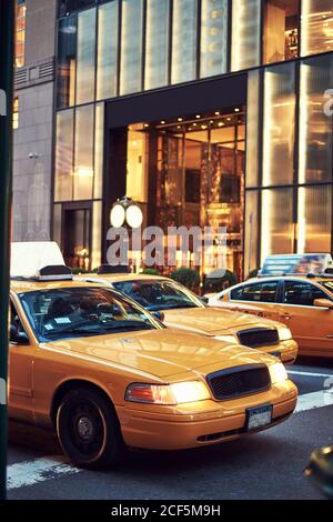 Des taxis jaunes modernes se trouvent dans une rue pavée du centre-ville Quartier de New York Banque D'Images