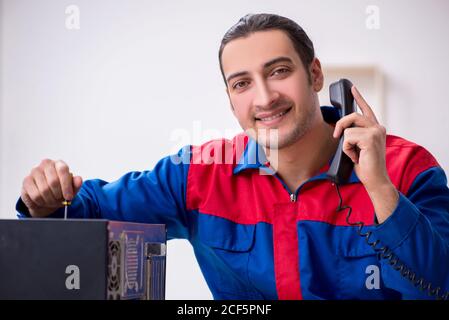 Jeune homme réparateur réparant un ordinateur PC Banque D'Images