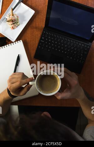 Indépendant assis à la table du café et buvant du café Banque D'Images