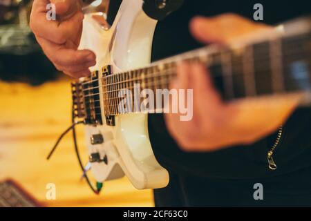 Rognez les mains de l'homme dans un studio de musique jouant une guitare Banque D'Images