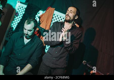 Un musicien hispanique adulte se claquant tout en chantant une chanson de flamenco sur scène Banque D'Images