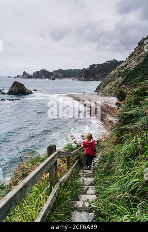 Femme marchant sur des marches de pierre menant à la mousse mer Banque D'Images