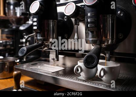 Machine à café professionnelle dans le restaurant qui sert de l'espresso fraîchement préparé deux tasses blanches Banque D'Images
