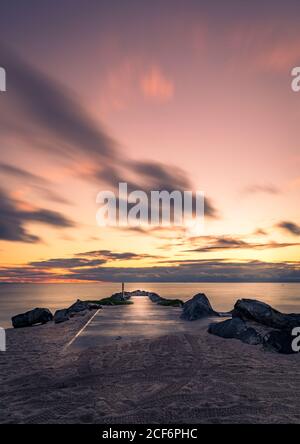 Magnifique coucher de soleil et nuages au bord de la mer avec bateau de pierre de jetée rampe Banque D'Images