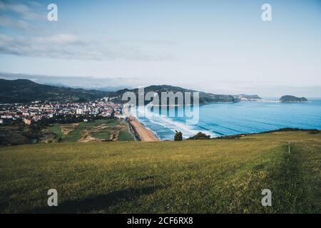 Vue pittoresque depuis la colline verdoyante de la ville paisible située dans vallée et entouré de rochers sur la mer le jour ensoleillé à Espagne Banque D'Images