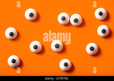 Arrière-plan d'Halloween, de nombreux yeux bulgés blancs sur fond orange Banque D'Images