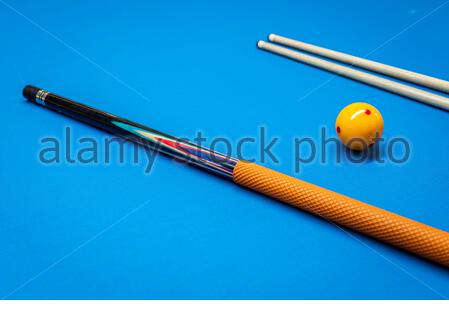 Des bâtons de repère et une boule jaune sur une table de billard. Banque D'Images
