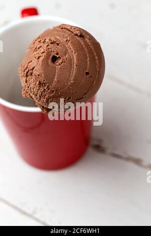 Cône de glace au chocolat dans une tasse rouge Banque D'Images