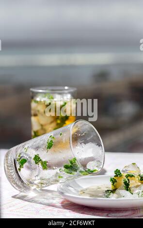 Du thé glacé avec des cubes d'eau congelés a été renversé sur la soucoupe avec du citron et menthe Banque D'Images