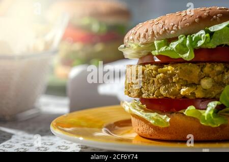 Hamburger de lentilles vert végétalien maison avec tomates, laitue et frites Banque D'Images