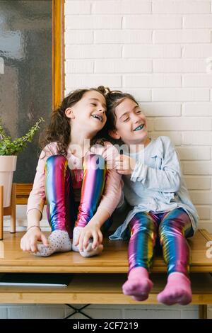 Deux sœurs souriantes qui sortent une langue bleue après avoir mangé une gomme à bulles bleue Banque D'Images