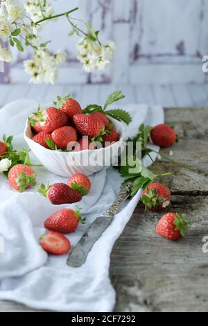 Dessert doux et crémeux accompagné de fraises fraîches et juteuses un verre sur une table rustique en bois Banque D'Images