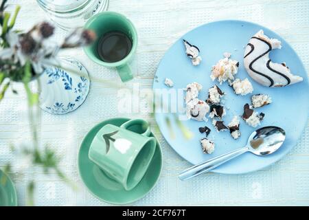 Videz le gobelet de la soucoupe et le plat de chapelure de pâte avec cuillère sur table Banque D'Images