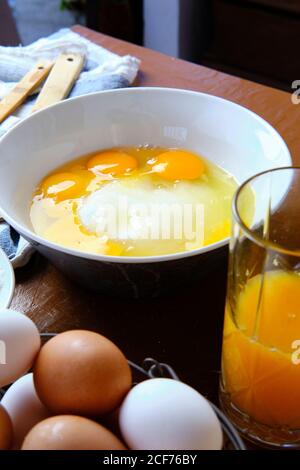 Œuf de poulet cru ajouté dans un bol avec du sucre pendant préparation de pâtisseries à la maison Banque D'Images