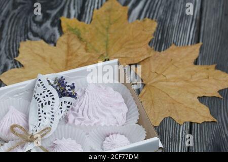 Zephyr dans une boîte, un bouquet de lavande et de feuilles d'érable séchées. Sur des planches de pin peintes. Banque D'Images