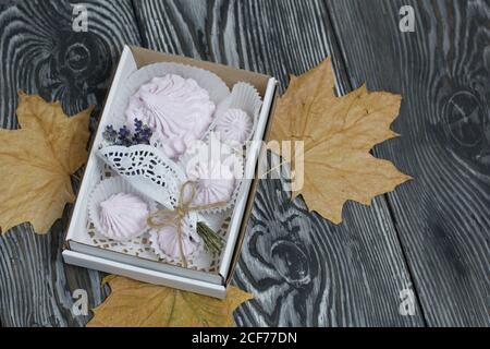 Zephyr dans une boîte, un bouquet de lavande et de feuilles d'érable séchées. Sur des planches de pin peintes. Banque D'Images